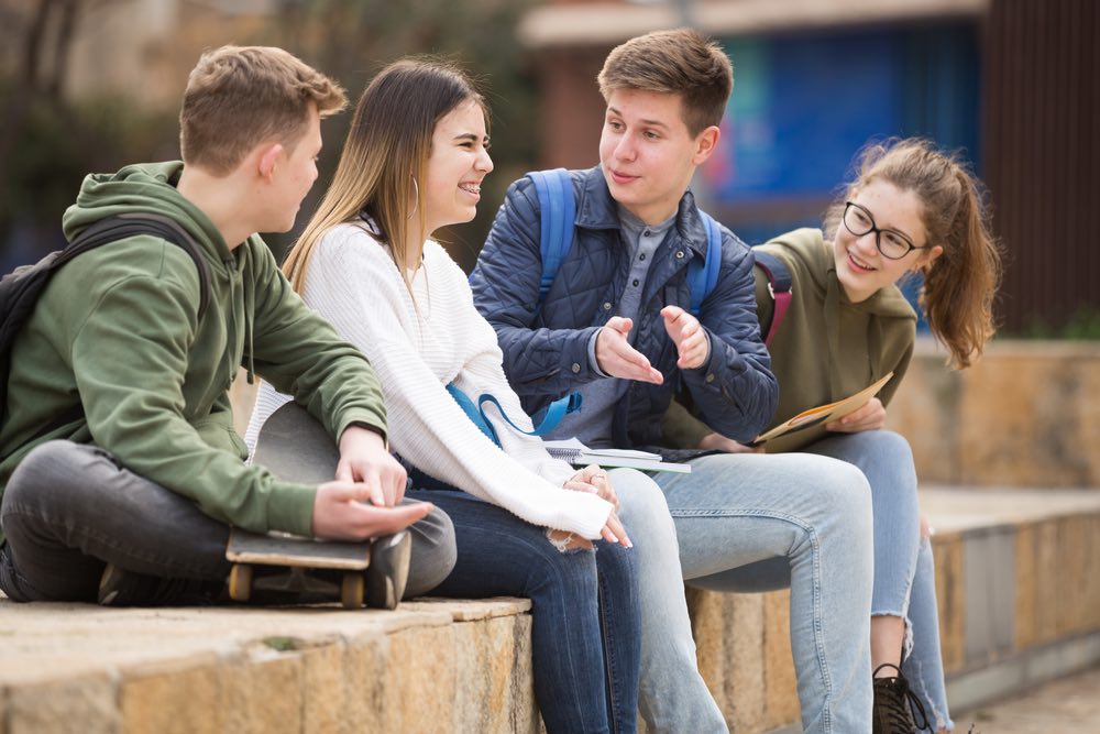 Adolescenti sul muretto che parlano